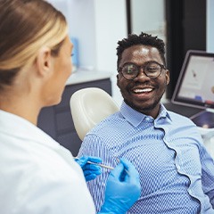 Smiling patient talking to dentist in treatment chair