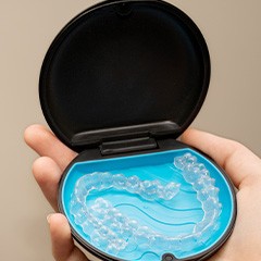 Patient holding clear aligner in case