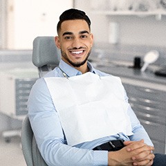 Man sitting in treatment chair with hands folded