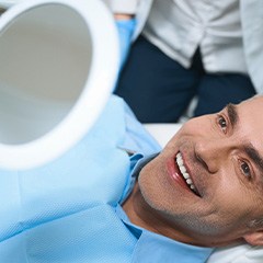 A man looking in the mirror at his dental implants