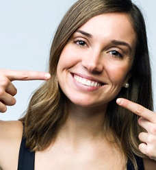 Woman pointing to her beautiful smile