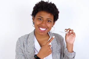 Happy young woman pointing at her Invisalign aligner