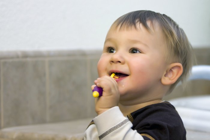 A young child brushing his teeth.