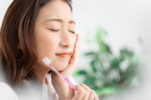 woman with poor brushing habits experiencing dental pain