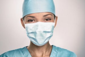 smiling dental team member wearing personal protective equipment