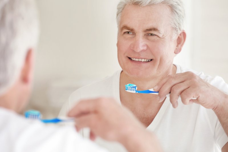 man brushing teeth in the mirror