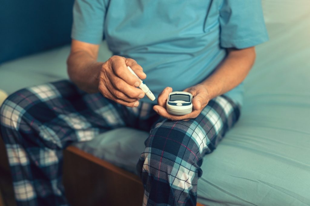 Patient with prediabetes checking his blood sugar level in the morning.