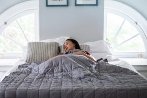 a person sleeping with a weighted blanket