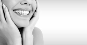 a patient’s smile against a gray background