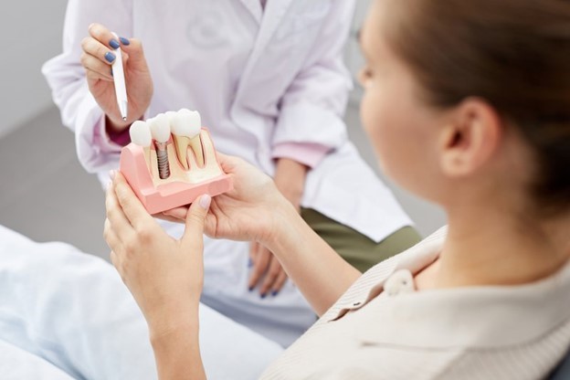 hygienist showing model to dental implant candidate 